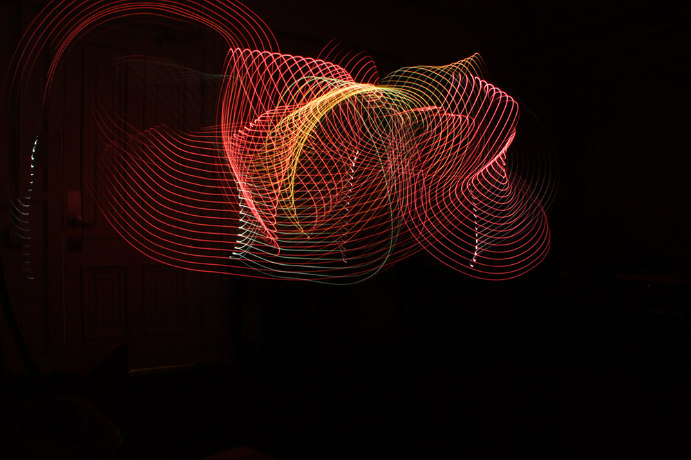 a long exposure photograph that shows bands of bright color spread across space in big, dramatic swirls